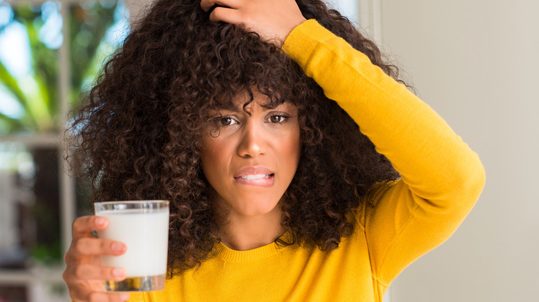 woman with milk holding head