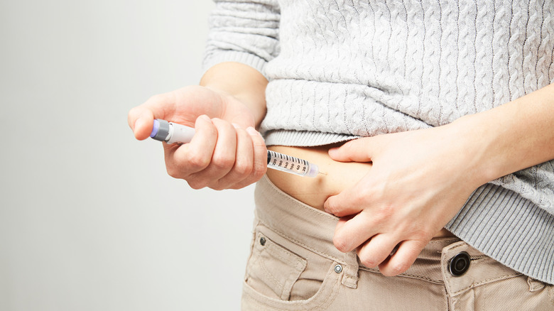 person injecting insulin