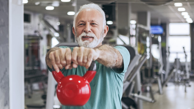 older adult holding a kettlebell