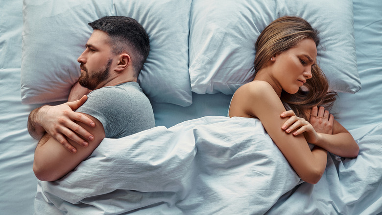 Couple in bed turned back to back