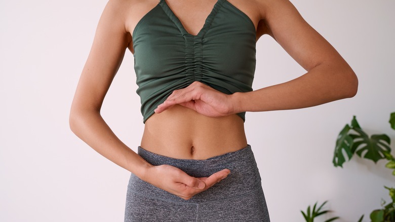 Woman circling her stomach with her hands