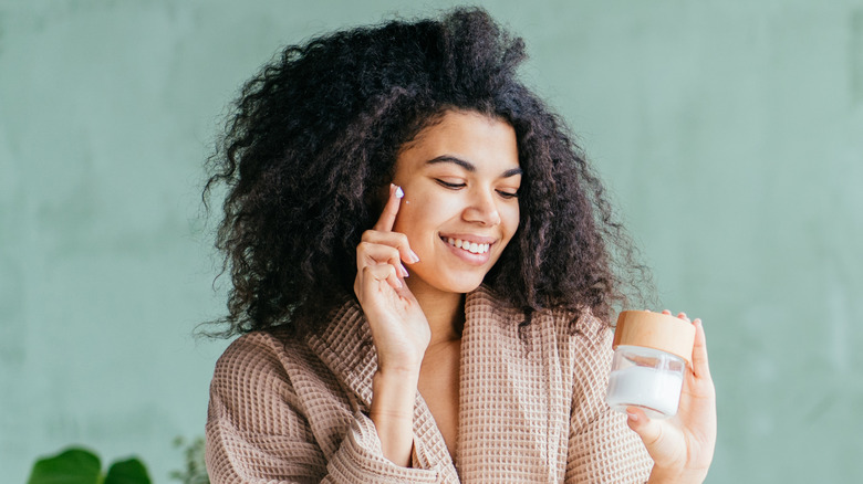 Woman applying moisturizer