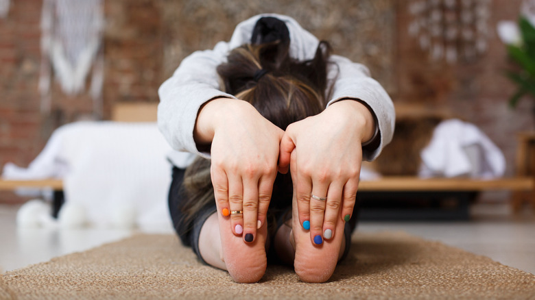 women stretching at the foot of her bed