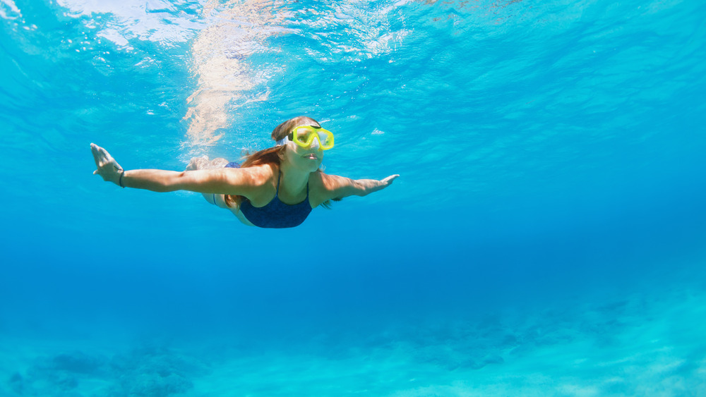 Woman with goggles swimming underwater