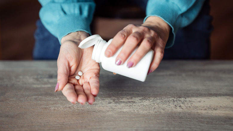 woman's hand holding pills