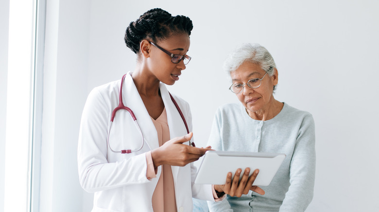 doctor talking with an older, female patient