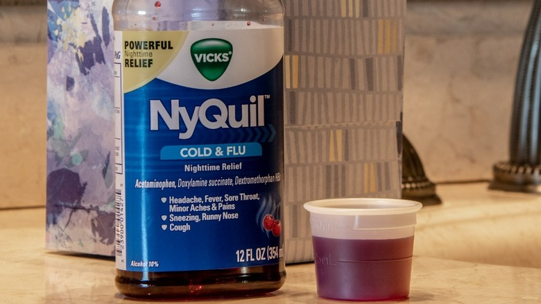 NyQuil on a vanity counter with shotglass