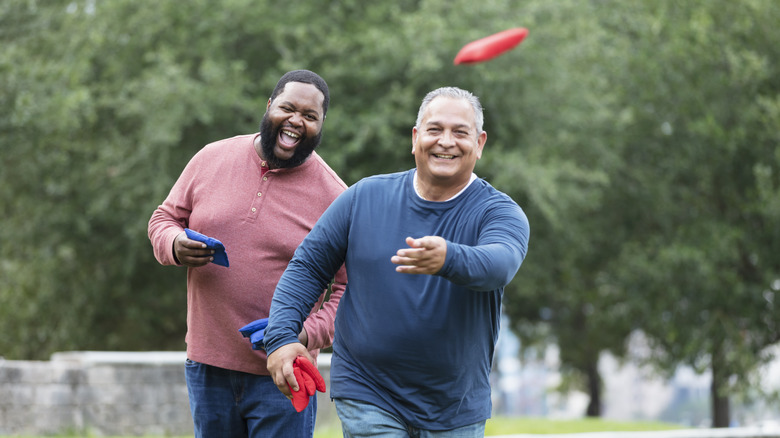 happy over-50 man exercising with friend
