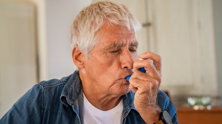 Older man using an inhaler