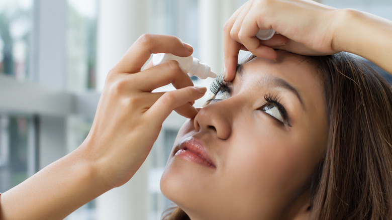 Woman applying eye drops