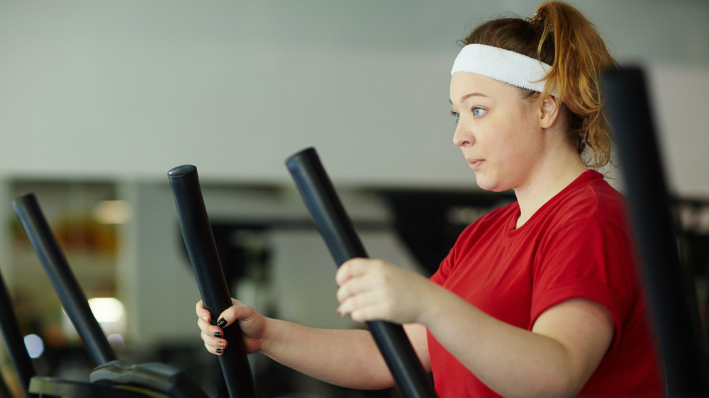 woman exercising on elliptical at gym