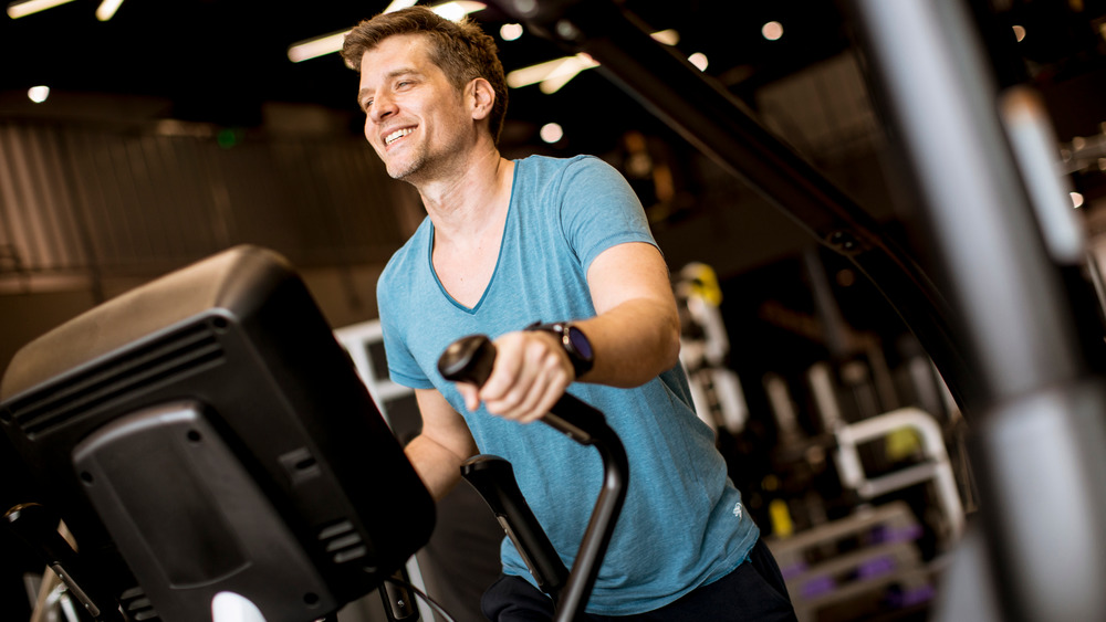 Smiling man using elliptical