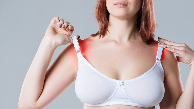 woman stretching her bra straps indicating pain on shoulders