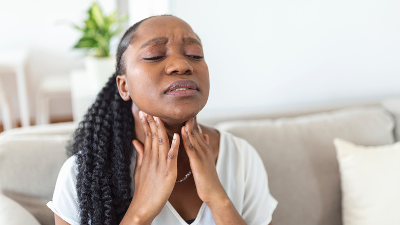 woman holding her neck in pain lymphatic system