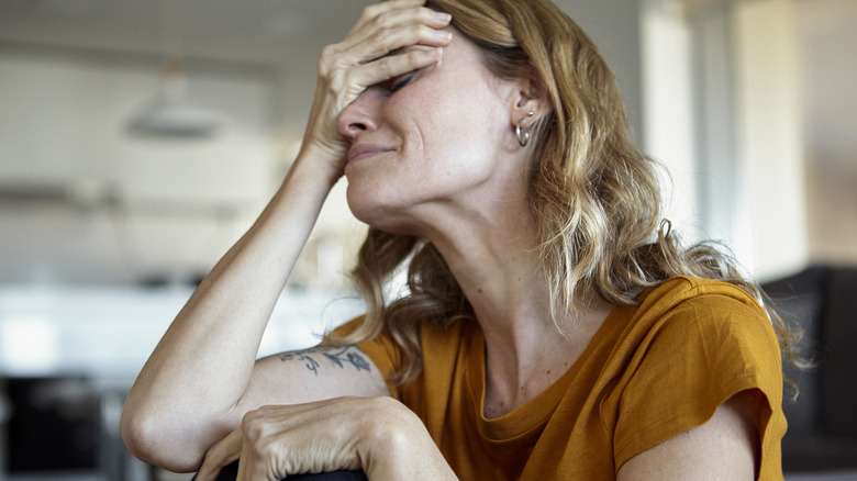 Young woman clutching her head crying