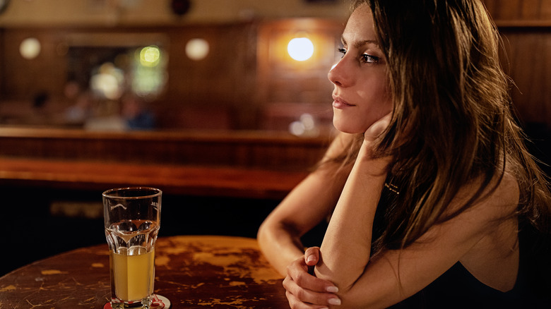 Woman sitting at the bar with sad face