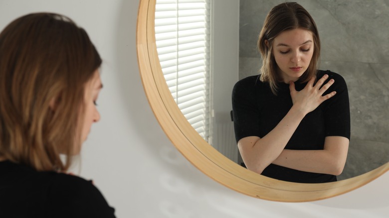 Sad young woman reflected in mirror