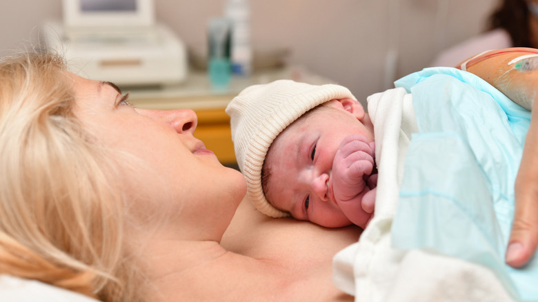 newborn baby in a cap with mother