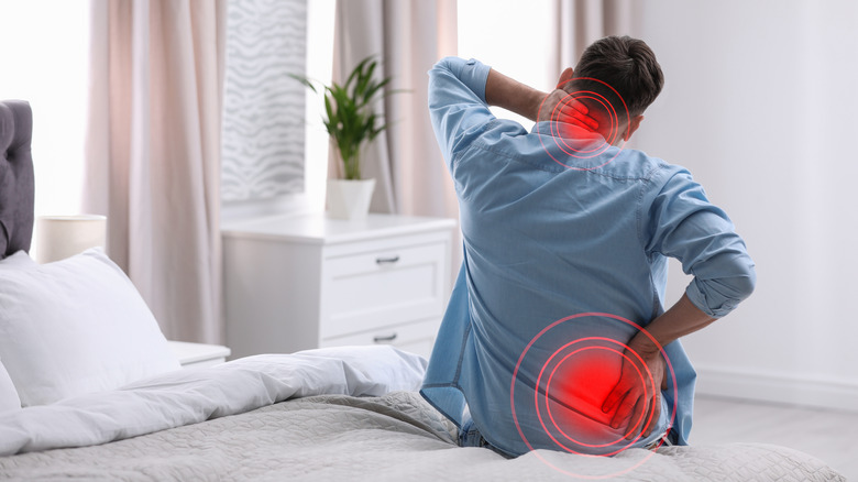 man sitting on bed suffering inflammation