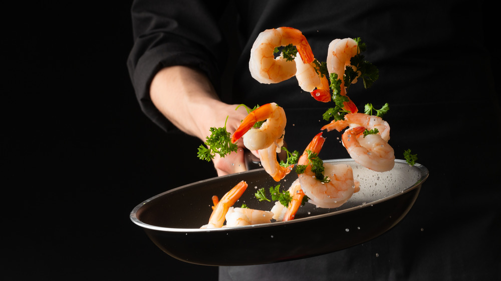 tossing shrimp in pan
