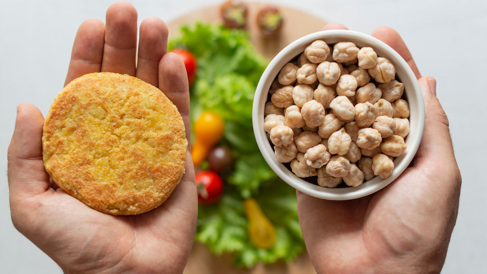 plant-based burger and chickpeas in hands