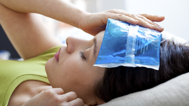 Woman holding cold compress to head