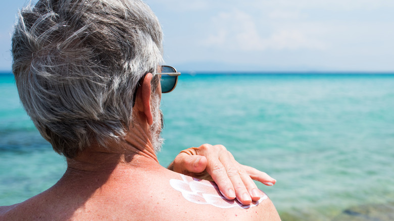 Man applying sunscreen to shoulder