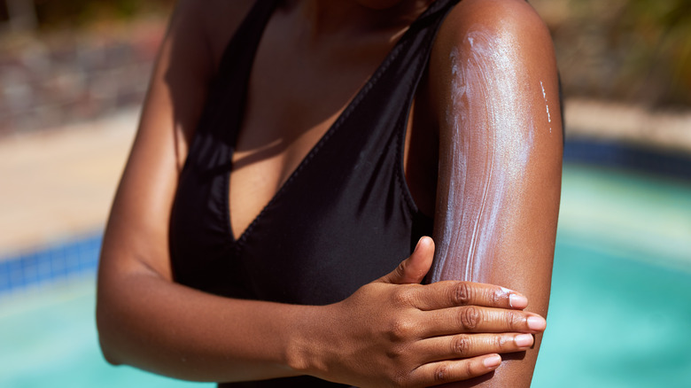 Woman applying sunscreen to arm