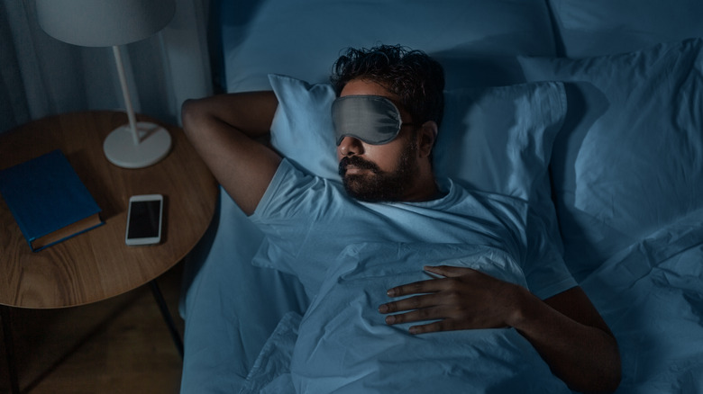 a man sleeping with an eye mask