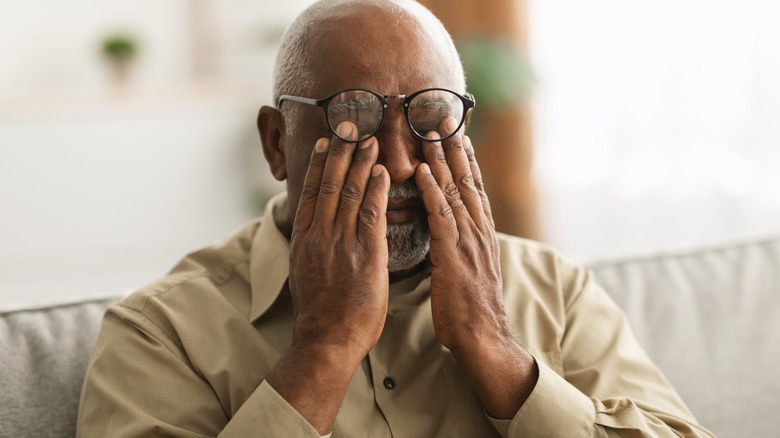 Senior man rubbing eyes