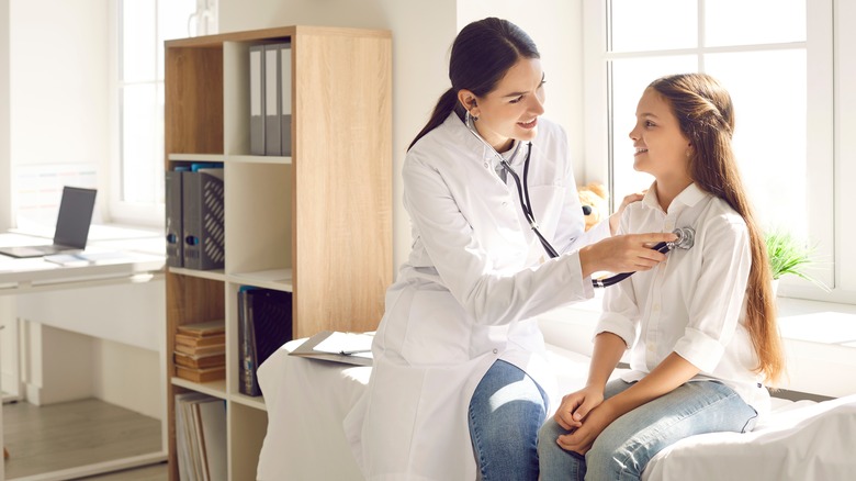 doctor checking patient's heart