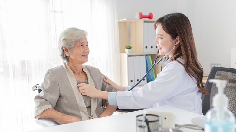 doctor checking patient's heart