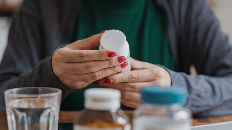 A woman's hands holding a medicine bottle