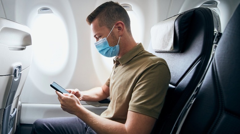 man on plane wearing mask