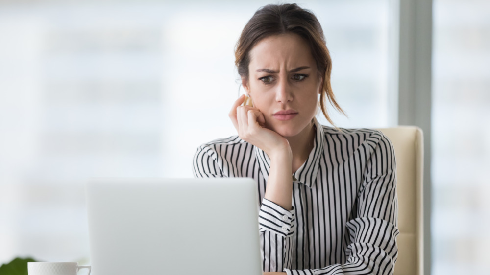 Confused businesswoman looking at laptop