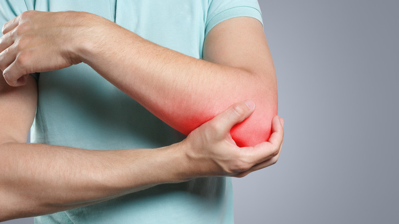 person holding elbow in pain