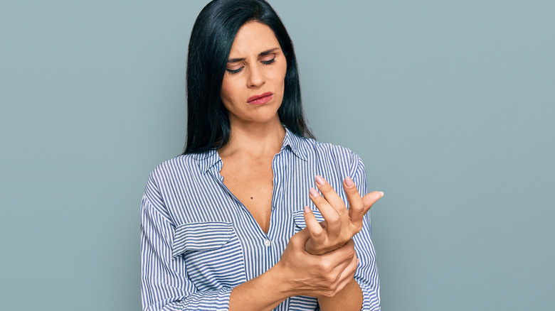 woman rubbing painful hands