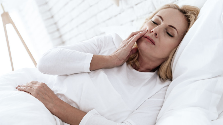 Sleeping woman touching side of face