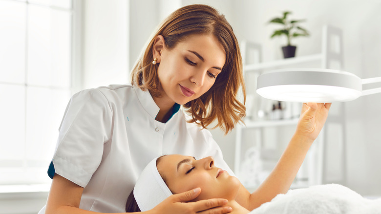 Dermatologist examines patient's skin