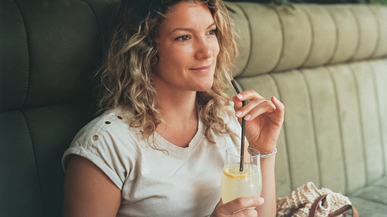 sitting woman holding lemonade straw