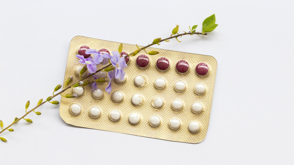 Oral contraceptive packet with purple flower