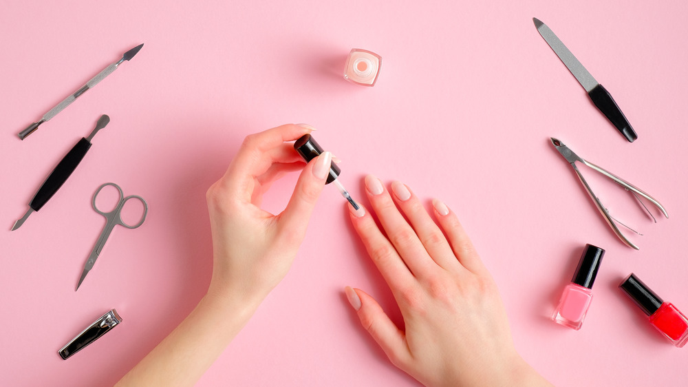 manicure with nail tools and a pink background 