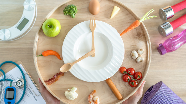 Plate with utensils and 12 foods arranged like clock face