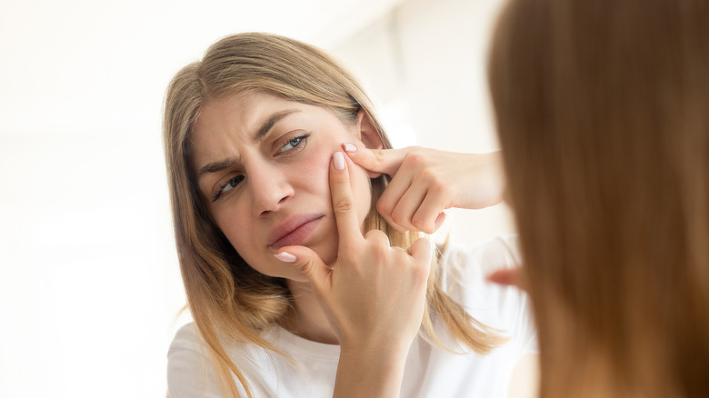 woman looking at skin tags on eyelids