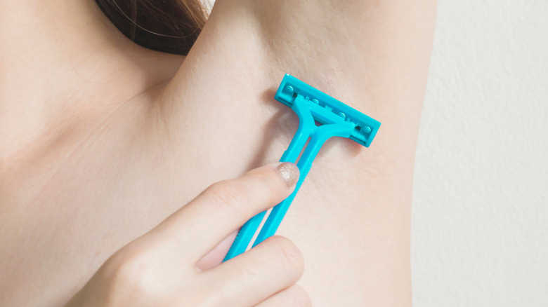 Woman shaving her armpit 