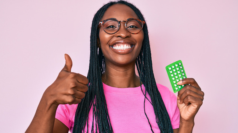 woman holding birth control pills 