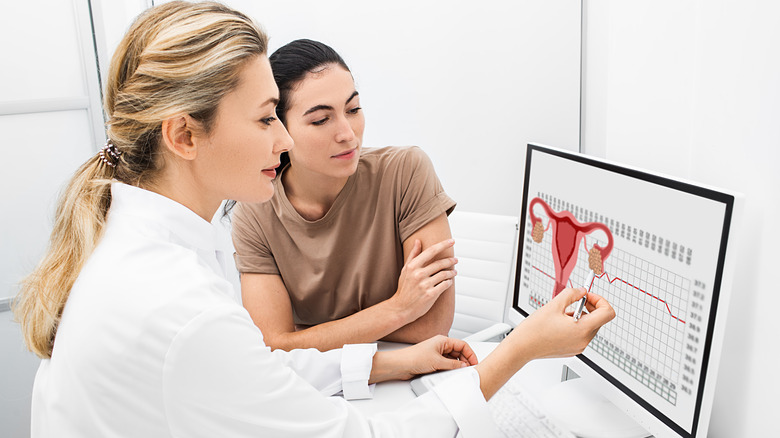 doctor using picture of uterus on computer to teach patient