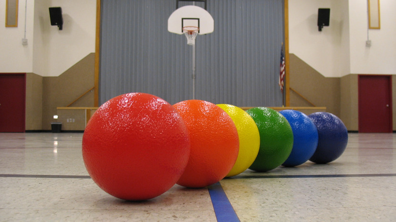 A set of colorful dodgeballs placed on a gymnasium floor