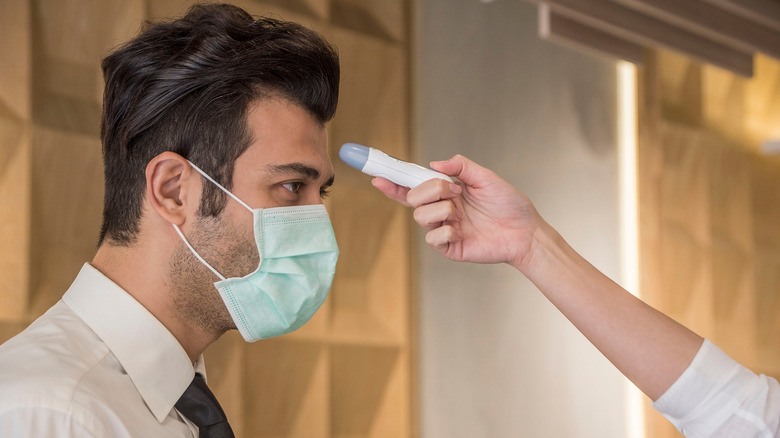 man getting forehead temperature reading