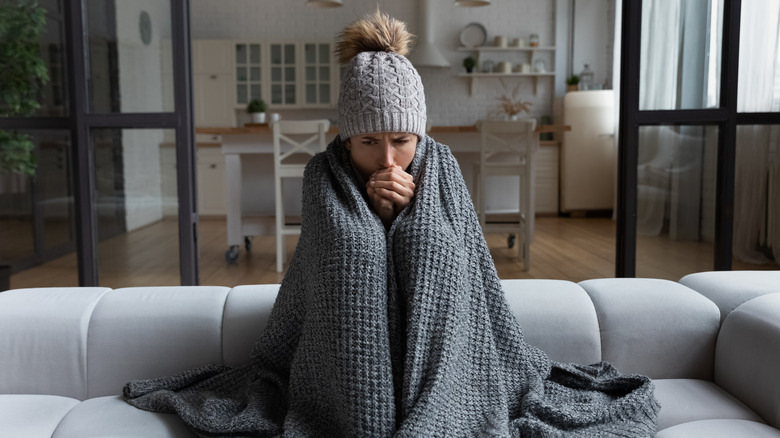 woman with blanket, hat on couch